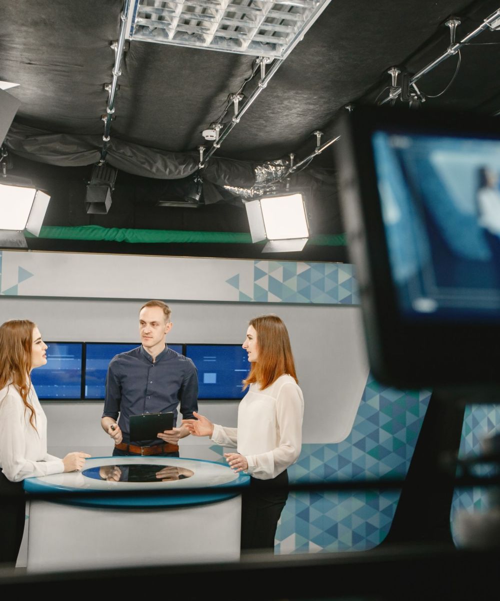 Camera filming tv show with host and two women